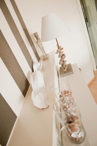 a white table with a lamp and a vase with shells at Hotel du Bassin in Ostend