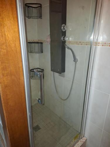 a shower with a glass door in a bathroom at papaye in Saint-Leu
