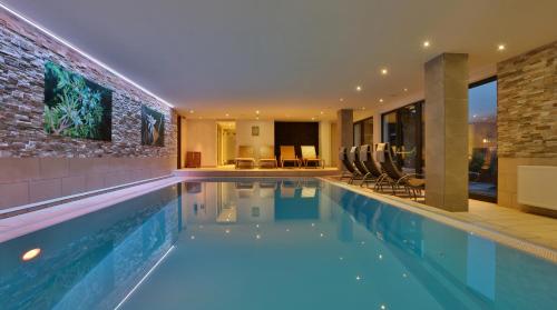 a swimming pool in a house with a building at Hotel Garni Fiegl Apart in Sölden