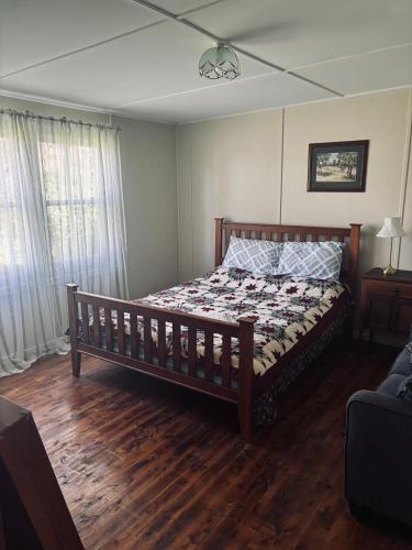 Schlafzimmer mit einem Bett und Holzboden in der Unterkunft Thronum Cottage in Mangoplah