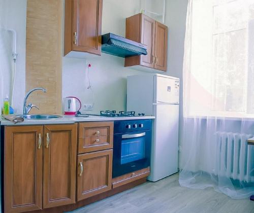 a kitchen with a stove and a refrigerator at Apartments on Sobornaya Street near the waterfront in Mykolaiv