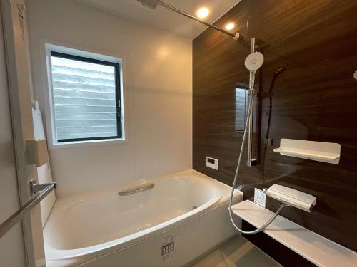 une salle de bain avec une baignoire et une fenêtre dans l'établissement eyehouse ozu No1, à Ozu