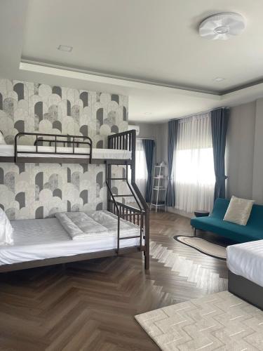 a bedroom with two bunk beds and a couch at Vela Pool Villa Hatyai in Sathani Khlong Rian