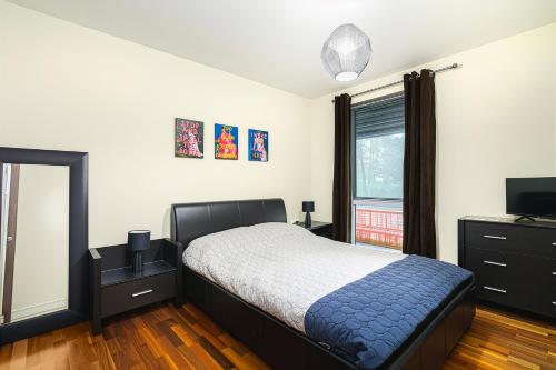 a bedroom with a bed and a dresser and a television at Modern 1BR Apartment near Edgbaston Cricket Ground in Birmingham