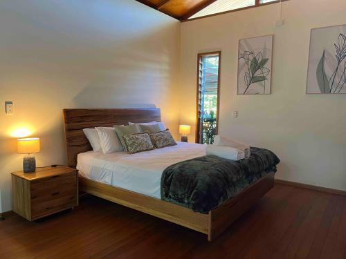 a bedroom with a large bed and a window at Lux rainforest lodge - 2 King bedrooms in Jogo