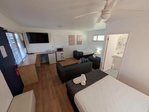a bedroom with a bed and a living room at Moffat Beach Motel Caloundra in Caloundra