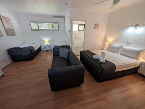 a large bedroom with a bed and a couch at Moffat Beach Motel Caloundra in Caloundra