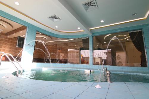 a swimming pool with a fountain in a building at Dorrat Al Nakheel Chalet in Buraydah