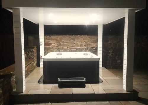 a bath tub in a room with a stone wall at Kirkcudbright Holiday Apartments - Apartment A in Kirkcudbright