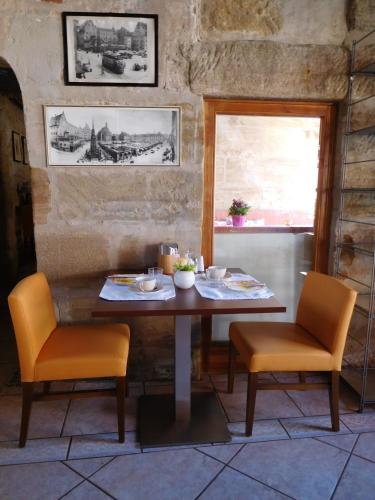 a table and two chairs in a room at Hotel Scheunenwerk - Nürnberg Nord in Heroldsberg