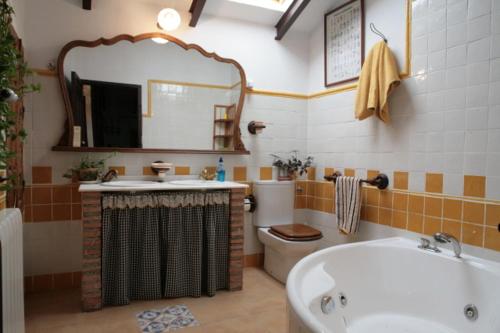 ein Badezimmer mit einer Badewanne, einem Waschbecken und einem WC in der Unterkunft Alojamiento Rural el Nolo in Chincolla