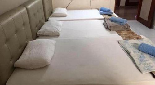 a row of white beds with pillows on them at Lai Ming Hotel Cosmoland in Singapore