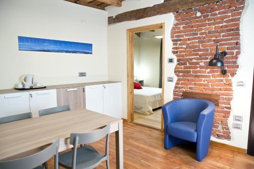 a kitchen and dining room with a brick wall at Osteria Senza Fretta Rooms for Rent in Cuneo