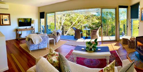 a living room filled with furniture and a large window at "La Petite Grange" Maleny in Maleny