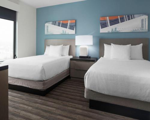 a hotel room with two beds and a table with lamps at Hyatt House Allentown-Lehigh Valley in Allentown