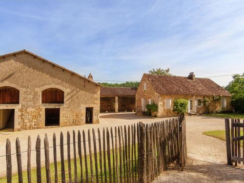 an old stone house with a wooden fence at Impressive restored farmhouse with private pool surrounded by woods in Campsegret