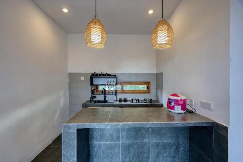 a kitchen with two pendant lights and a counter at Kampuak Cottages in Nusa Penida