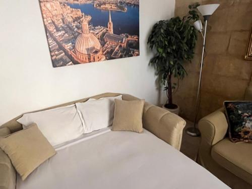 a living room with a couch and a picture on the wall at 300 years old Maisonette in Beautiful Stairs in Valletta