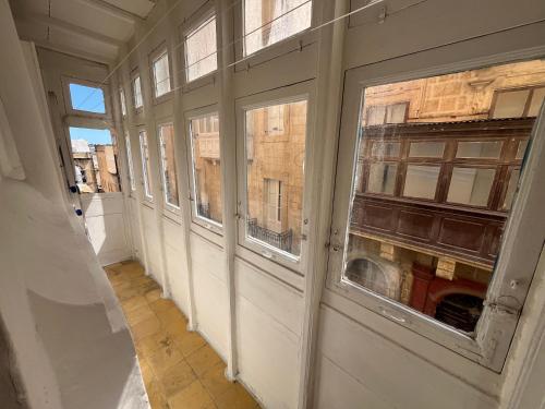 an empty hallway with windows in a building at 300 years old Maisonette in Beautiful Stairs in Valletta