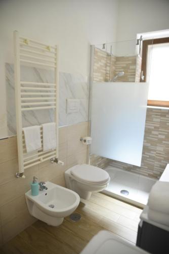 a bathroom with a toilet and a sink and a shower at TOI Apartments in Brindisi