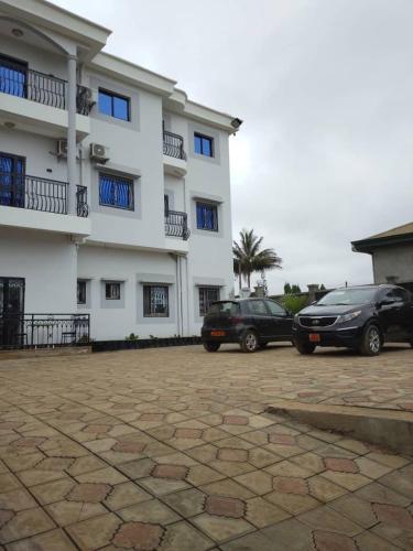 two cars parked in front of a building at Aloha Suites Odza - by Skyline Residence Services in Yaoundé