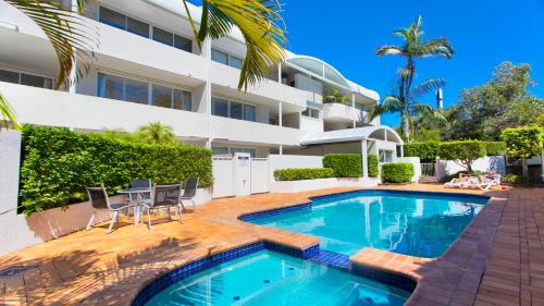 a swimming pool in front of a building at 6- 'Cote D'Azur' 6 Douglas Street Sunshine Beach in Sunshine Beach