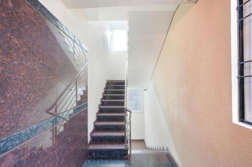 a staircase in a building with a red wall at FabHotel Royal Suites I in Bengaluru
