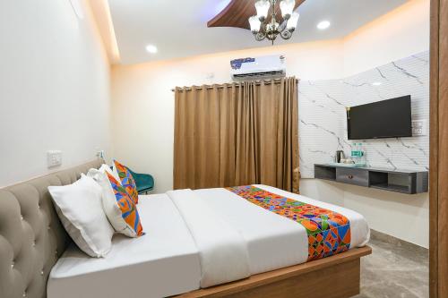 a hotel room with a bed and a television at FabHotel Royal Suites I in Bengaluru