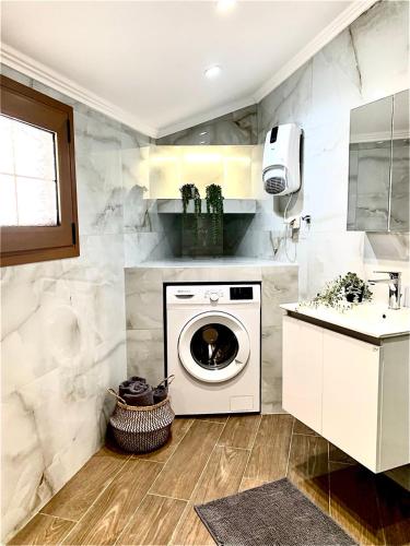 a bathroom with a washing machine and a sink at Eleni's Traditional House in Afantou