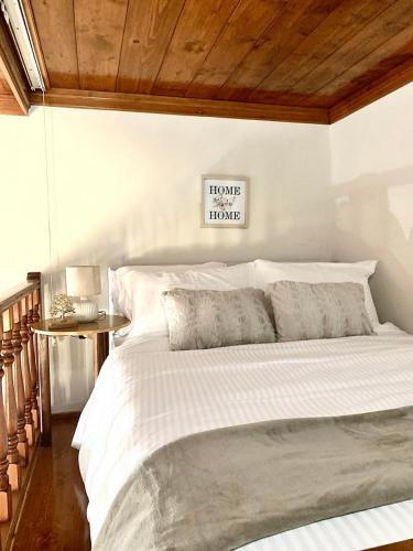 a bedroom with a white bed with a wooden ceiling at Eleni's Traditional House in Afantou