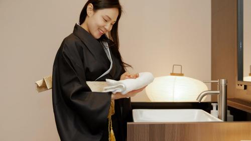 a woman in a graduation gown holding a diploma at Aank Ryokan Hotel Paju in Paju