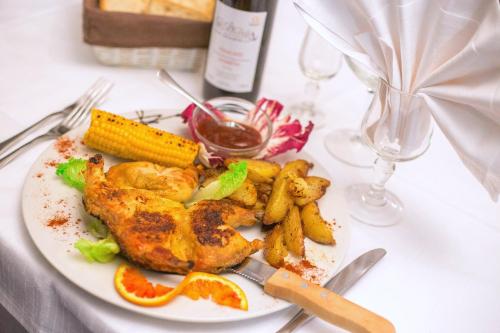 a plate of food with chicken and vegetables on a table at Hotel Ristorante La Perla in Varallo Pombia