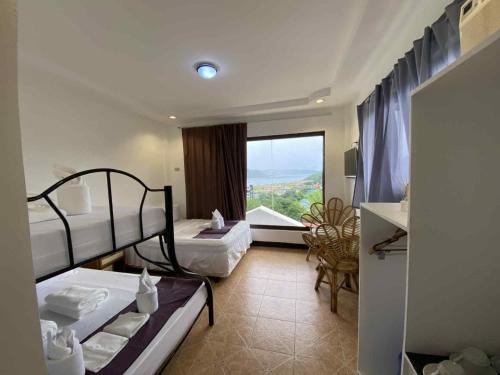 a hotel room with two bunk beds and a window at Oceana Bay Coron in Coron