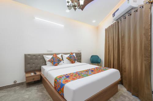 a bedroom with a large bed and a chandelier at FabHotel Royal Suites I in Bengaluru