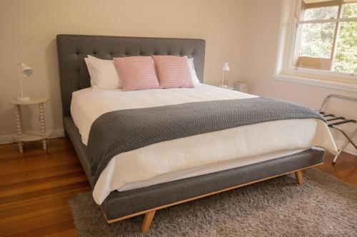 a bedroom with a large bed with pink pillows at Webster Hideaway in Wendouree