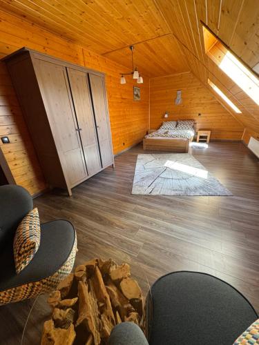 a room with a bed and chairs in a cabin at Beskidzki Domek Kurów in Kurów