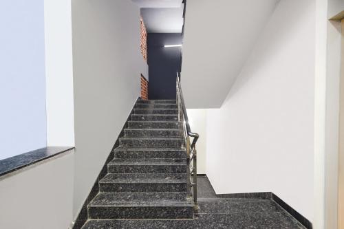 a stairway leading up to a white wall at FabHotel Yendluri's Abode in Lingampalli