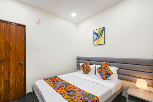 a bedroom with a bed and a wooden door at FabHotel Yendluri's Abode in Lingampalli