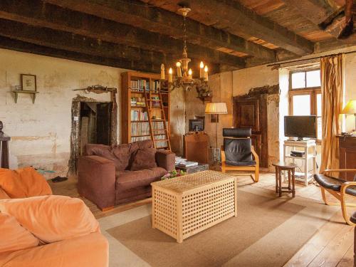 a living room with a couch and a table at Dreamy Holiday Home in Clermont d Excideuil with Fireplace in Saint-Médard-dʼExcideuil