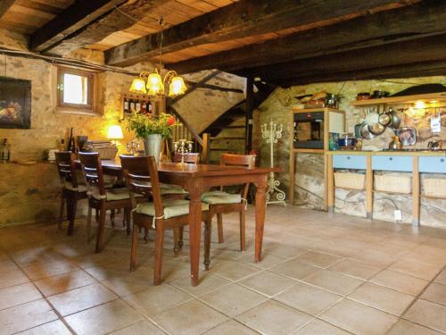 a dining room with a wooden table and chairs at Dreamy Holiday Home in Clermont d Excideuil with Fireplace in Saint-Médard-dʼExcideuil