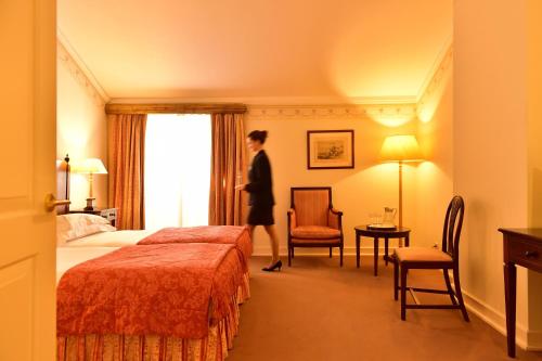 a woman is standing in a hotel room at Pousada Palacio de Queluz in Queluz