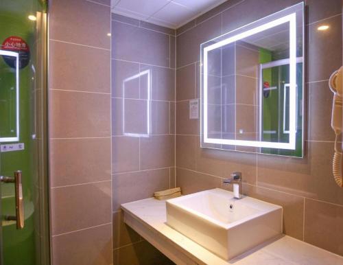 a bathroom with a sink and a mirror at GreenTree Inn Jinzhong PinGYAo City South Railway Station Express Hotel in Pingyao