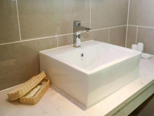 a white bathroom sink with a faucet on a counter at GreenTree Inn Jinzhong PinGYAo City South Railway Station Express Hotel in Pingyao