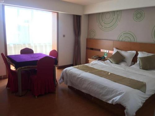 a hotel room with a large bed and a window at GreenTree Inn Jinzhong PinGYAo City South Railway Station Express Hotel in Pingyao