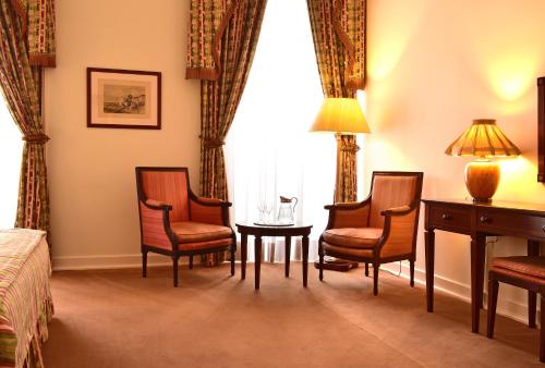 a hotel room with chairs and a table and a window at Pousada Palacio de Queluz in Queluz