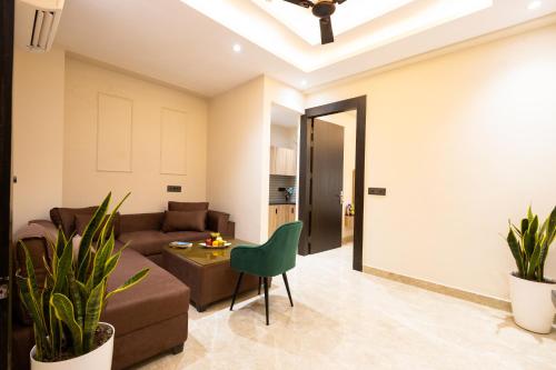 a living room with a couch and a table at Leaf 9 Grand, Near Udyog vihar and Yashobhoomi in Gurgaon