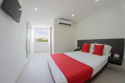 Un dormitorio con una cama grande con almohadas rojas. en Massay Hotel, en Neiva