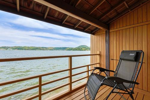 a chair sitting on a porch looking out at the water at Sennentei in Yurihama