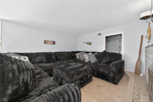 a living room with a black couch and a fireplace at Lakefront Getaway with Private Dock & Scenic Views home in Gray