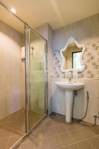 a bathroom with a sink and a shower with a mirror at Harmonize Hotel Chiang Mai in Chiang Mai